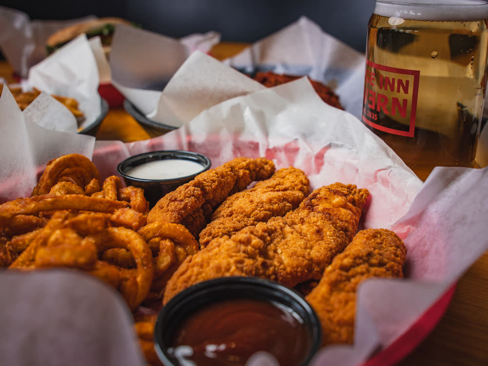 Friends sharing food and drinks at Barge Inn Tavern, Newport's bayfront tavern since 1935